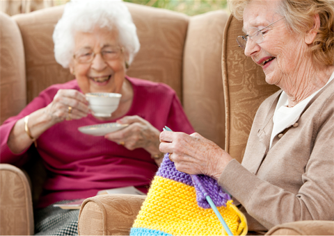 one person drinking a coffee and another person knitting